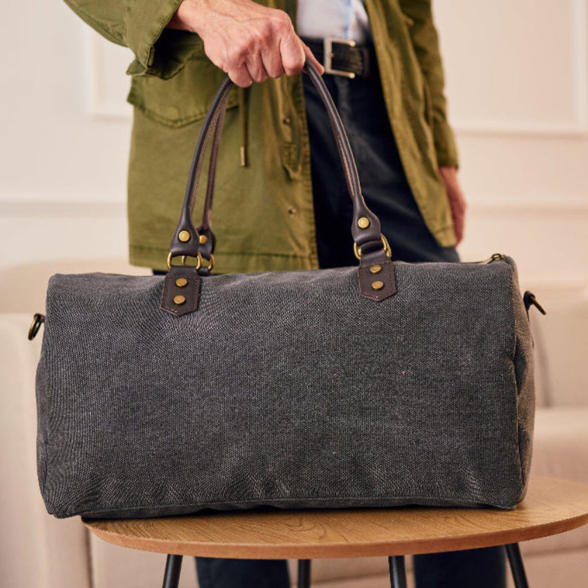 Gray duffel bag with black straps 
