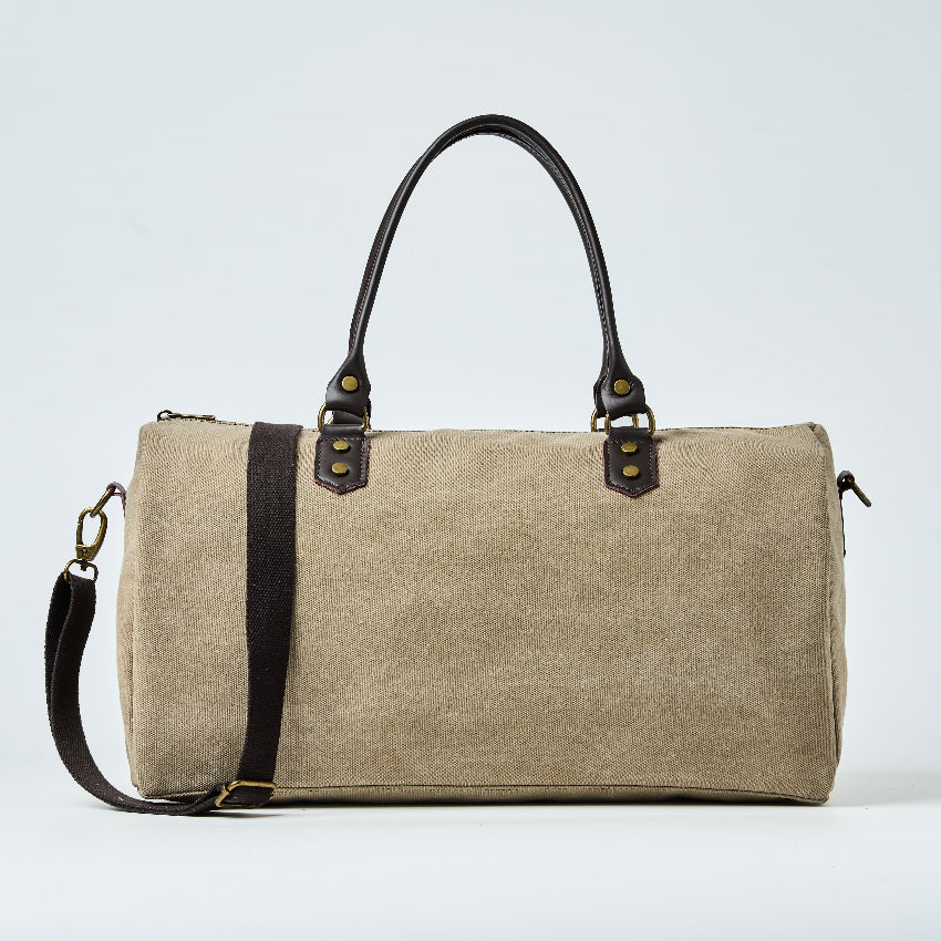 Beige duffel bag with black straps on a light gray background

