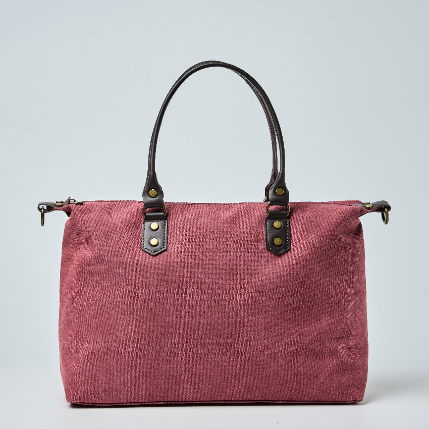 Burgundy tote bag with black straps on a light gray background