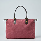 Burgundy tote bag with black straps on a light gray background