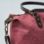 Burgundy tote bag with black straps on a light gray background