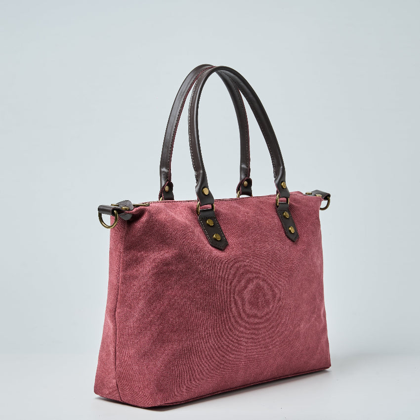 Burgundy tote bag with black straps on a light gray background